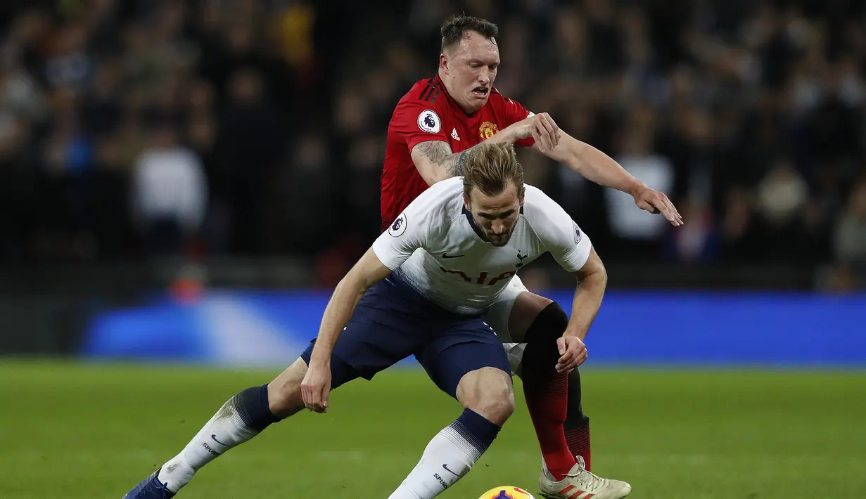 Duel Harry Kane dengan Phil Jones pada laga lanjutan Premier League yang berlangsung di stadion Wembley, Inggris, Minggu (13/1). Man United menang atas Tottenham Hotspur 1-0. (AFP/Adrian Dennis)