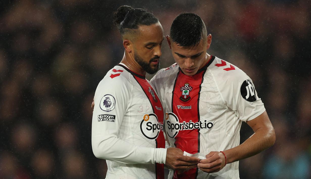 Pemain Southampton, Carlos Alcaraz (kanan) berbincang dengan rekannya Theo Walcott pada laga lanjutan Liga Inggris 2022/2023 melawan Bournemouth di St Mary's Stadium, Southampton, Inggris, 27 April 2023. Saat ini, Acaraz memiliki harga pasar sebesar 12 juta euro. Ia terikat kontrak dengan The Saint hingga tahun 2027. (AFP/Adrian Dennis)