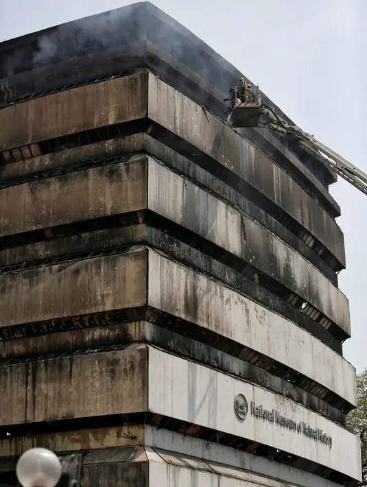 Petugas pemadam kebakaran berusaha memadamkan api yang menghanguskan Museum Nasional Sejarah Alam di Ibu Kota India, New Delhi, Selasa (26/4). Sebanyak 35 mobil pemadam dikerahkan untuk memadamkan kobaran api. (REUTERS/Anindito Mukherjee)