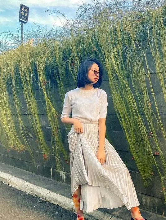 Simpel tapi modis, Zara memadukan long sleeve top dengan rok plisket. Aksesori berupa kacamata bikin penampilannya makin chic. (Instagram/zara_leola_official).
