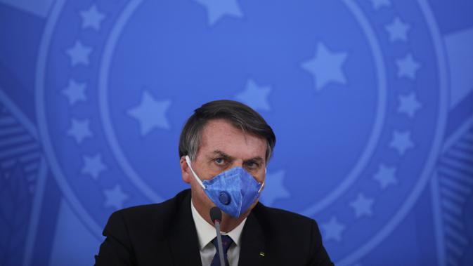 Presiden Brasil Jair Bolsonaro mengenakan masker saat konferensi pers mengenai pandemi virus corona COVID-19 di Istana Planalto, Brasilia, Brasil, 20 Maret 2020. (Sergio LIMA/AFP)