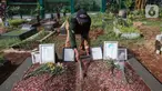 Sardi, pengurus makam membersihkan makam Vanessa Angel dan Bibi Ardiansyah di TPU Taman Makam Islam Malaka Blok D, Pesanggrahan, Jakarta, Senin (7/02/2022). Makam yang berada di atas tanah wakaf dirapikan dengan semen oleh pengurus makam agar tanah tidak amblas. (Liputan6.com/Fery Pradolo)