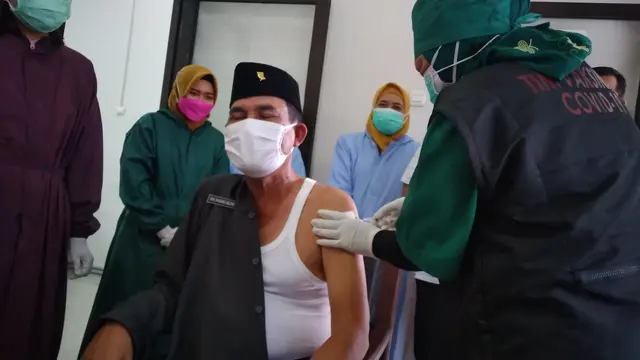 Ketua DPRD Kabupaten Blora, HM Dasum saat disuntik vaksin Covid-19. (Liputan6.com/Ahmad Adirin)
