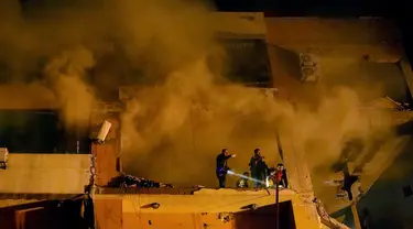 Asap mengepul dari apartemen yang hancur saat pekerja pertahanan sipil mencari korban yang selamat menyusul ledakan besar di Dahiyeh, pinggiran selatan Beirut, Lebanon, Selasa (2/1/2024). (AP Photo/Bilal Hussein)