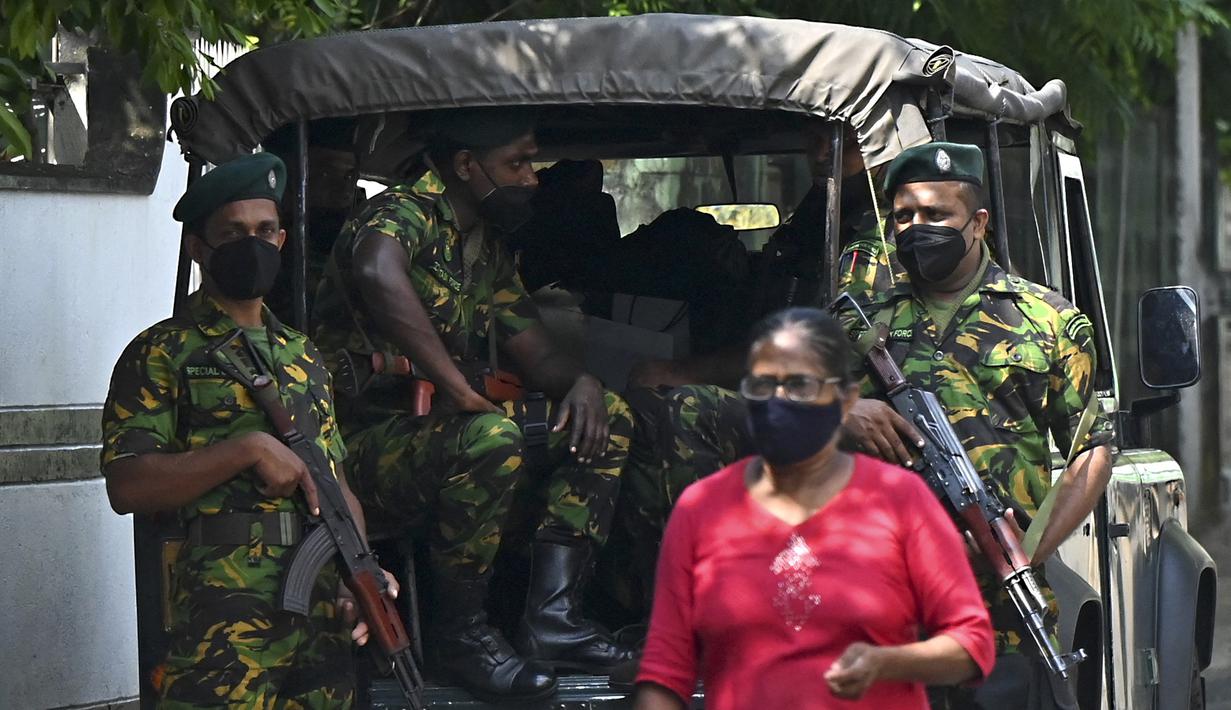 Seorang pejalan kaki melewati Satuan Tugas Khusus (STF) yang berjaga di sepanjang jalan di Kolombo pada Sabtu (2/4/2022). Pasukan militer dikerahkan di Sri Lanka, beberapa jam setelah presiden mengumumkan keadaan darurat ketika protes terhadapnya meningkat. (KODIKARA / AFP)