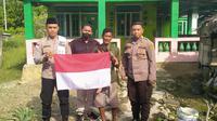 Personel Satgas Madago Raya membagikan Bendera Merah Putih kepada salah satu warga Poso jelang Hari Kemerdekaan, Senin (8/8/2022). (Foto: Humas Satgas Madago Raya).