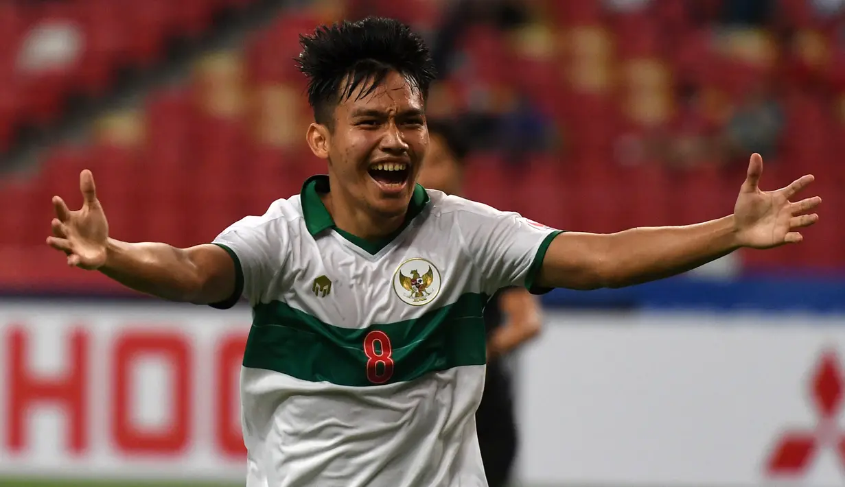 Pemain Indonesia Witan Sulaeman melakukan selebrasi usai mencetak gol ke gawang Singapura pada pertandingan leg pertama semifinal Piala AFF 2020 di National Stadium, Singapura, Rabu (22/12/2021). Pertandingan berakhir imbang 1-1. (Roslan RAHMAN/AFP)