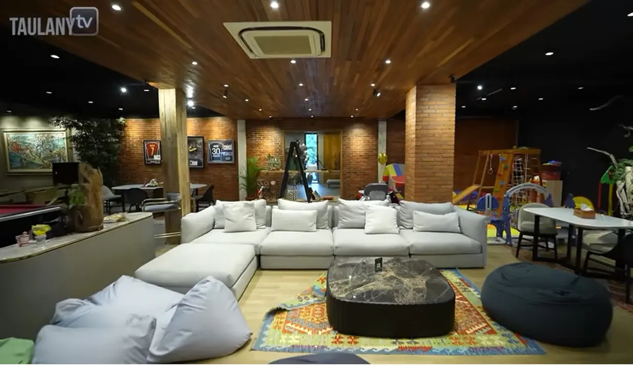 Ruang santai untuk karyawan Baim Paula yang nyaman dengan meja dan beberapa sofa. Diruang ini juga ada televisi besar dan disebelahnya terdapat pendingin. [Youtube/TAULANY TV]