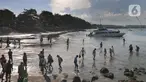 Wisatawan antre naik ke kapal boat menuju kawasan wisata Nusa penida dan Nusa lembongan di Pelabuhan Sanur, Denpasar, Bali, Senin (2/5/20222). Libur panjang lebaran tahun ini berdampak positif kepada jumlah keberangkatan wisatawan menuju Nusa Penida ataupun Nusa Lembongan. (merdeka.com/Arie Basuki)