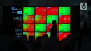 Karyawan melintasi layar yang menampilkan Indeks Harga Saham Gabungan (IHSG) saat acara Penutupan Perdagangan Bursa Efek Indonesia Tahun 2022 di Jakarta, Jumat (30/12/2022). PT Bursa Efek Indonesia (BEI) mencatat ada 59 perusahaan yang melakukan Initial Public Offering (IPO) atau pencatatan saham sepanjang 2022. Pada penutupan perdagangan akhir tahun, Indeks Harga Saham Gabungan (IHSG) ditutup lesu 0,14% atau 9,46 poin menjadi 6.850,62. (Liputan6.com/Angga Yuniar)