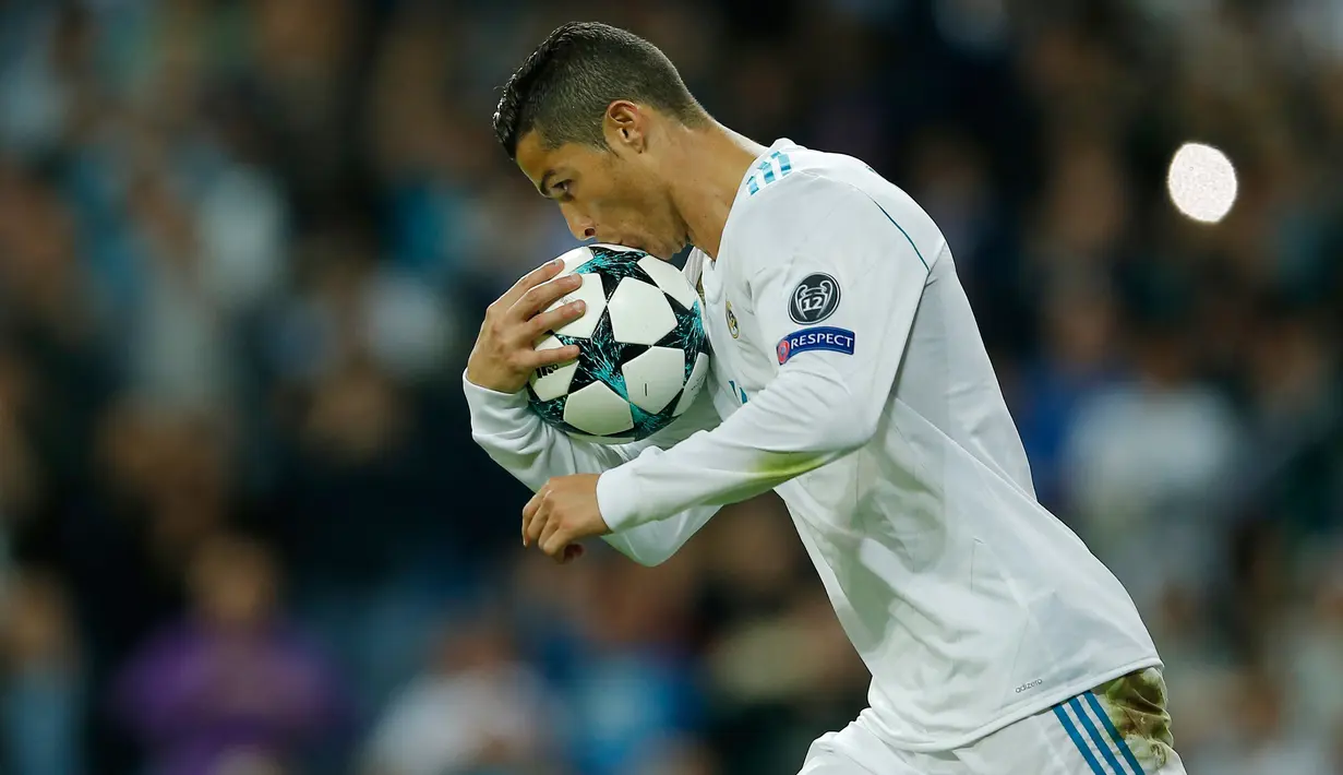 Pemain Real Madrid, Cristiano Ronaldo mencium bola setelah mencetak gol lewat penalti pada laga lanjutan babak penyisihan Grup H Liga Champions di Santiago Bernabeu, Selasa (17/10). Madrid ditahan imbang tamunya Tottenham Hotspur 1-1.  (AP/Francisco Seco)