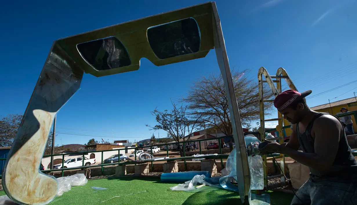 Seorang pekerja mengecek kaca mata raksasa untuk melihat gerhana matahari total di La Higuera, Wilayah Coquimbo, di gurun Atacama Santiago, Chile (1/7/2019). (AFP Photo/Martin Bernetti)