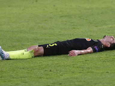 Kiper Krasnodar, Magomed-Shapi Suleymanov, terbaring lesu di lapangan usai ditaklukkan Sevilla pada laga Liga Champions di Stadion Ramon Sanchez Pijuan, Kamis (5/11/2020). Sevilla menang dengan skor 3-2. (AP Photo/Miguel Morenatti)