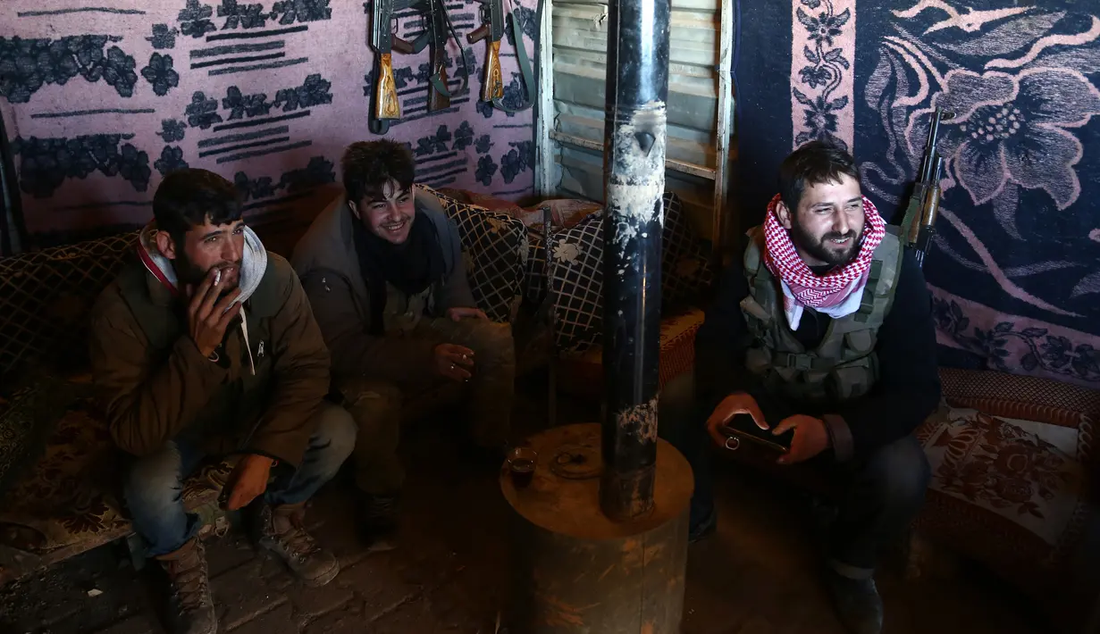 Tentara Pembebasan Suriah (FSA) yang didukung Turki duduk di sebuah tenda di Tal Malid, sebelah utara Aleppo, saat bersiap untuk menargetkan posisi Unit Pertahanan Rakyat Kurdi (YPG) di wilayah Afrin, Suriah, Sabtu (20/1). (AFP FOTO/Nazeer al-Khatib)