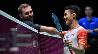 Tunggal putra Indonesia, Jonatan Christie tersenyum saat bersalaman dengan Jan O Jorgensen  dari Denmark usai bertanding dalam babak semifinal Jepang Terbuka 2019  di Tokyo (27/7/2019). Jonatan Christie akan melawan Kento Momota dari Jepang di babak final. (AFP Photo/Toshifumi Kitamura)