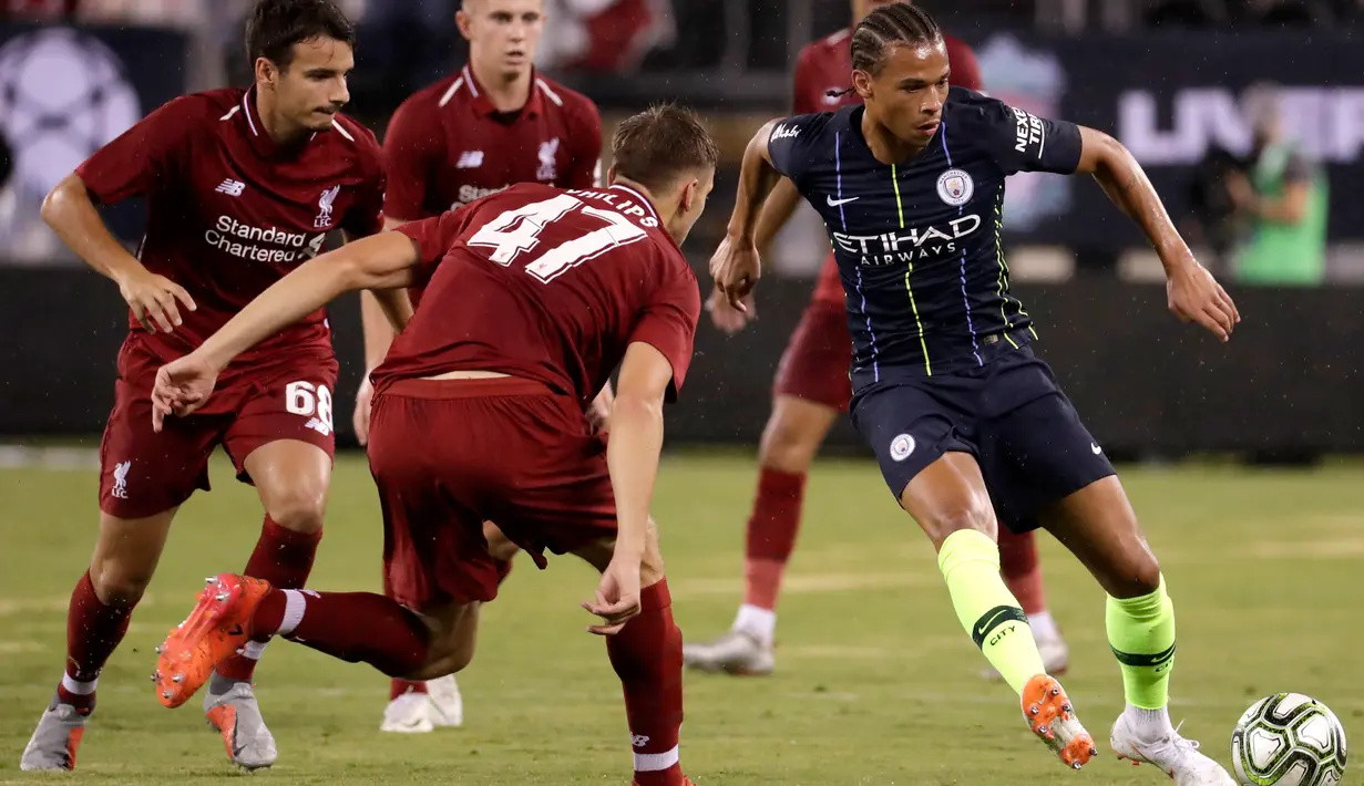 Gelandang Manchester City Leroy Sane menggiring bola dari kawalan para pemain Liverpool saat bertanding pada International Champions Cup di East Rutherford, N.J. (25/7). Liverpool menang 2-1 atas City. (AFP Photo/Kena Betancur)