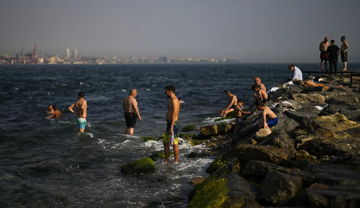 <p>Orang-orang mendinginkan diri pada musim panas yang terik di Bosphorus, Istanbul, Turki, 13 Juli 2023. (AP Photo/Francisco Seco)</p>
