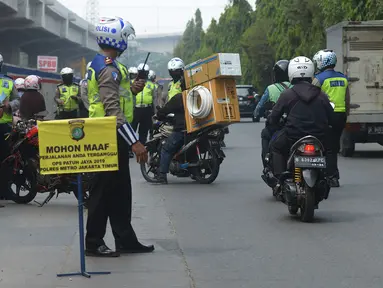 Polisi lalu lintas memberhentikan pengendara sepeda motor saat menggelar razia Operasi Patuh Jaya 2019 di kawasan Kebon Nanas, Jakarta, Kamis (29/8/2019). Diketahui, Operasi Patuh Jaya 2019 di wilayah hukum Polda Metro Jaya mulai digelar hari ini hingga 11 September 2019. (merdeka.com/Imam Buhori)