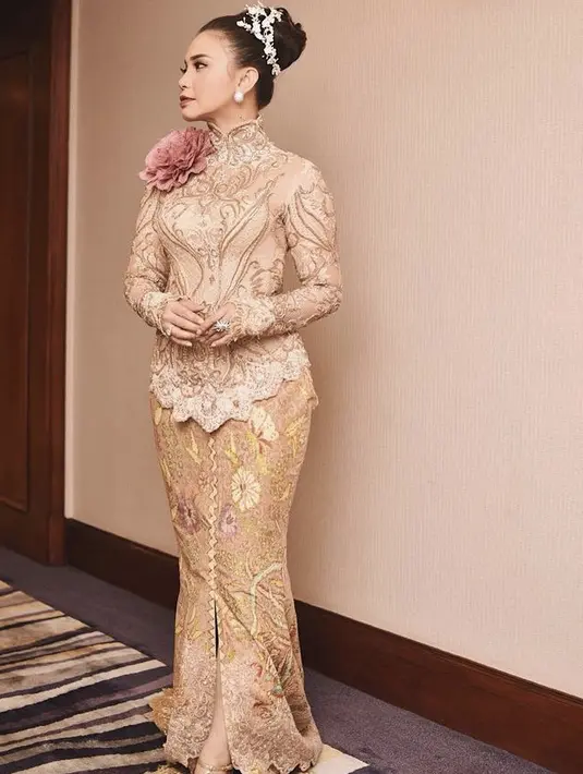 Kebaya mewah warna nude penuh bordir dengan aksesori bunga mawar besar pun dikenakan oleh Rossa. Dipadukan dengan kain bergaya mermaid dengan detail bordiran. (@itsrossa910)