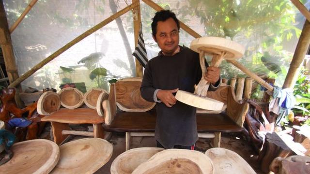 Hasyim, perajin furniture akar kayu. (Dhita/Liputan6.com)