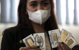 Pramuniaga menunjukkan emas batangan PT Aneka Tambang (Antam) Tbk di sebuah gerai emas, Jakarta, Senin (18/1/2021). Pada hari ini, harga emas Antam turun menjadi Rp 944 ribu per gram. (Liputan6.com/Johan Tallo)