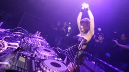 DJ Butterfly berjoged sambil memainkan musiknya di Lantai dansa Colosseum Jakarta, Rabu (8/3). Selain kemampuanya menjadi FDJ, wanita berdarah Thailand itu ternyata punya bakat lain seperti bernyanyi dan menari, serta modeling. (Liputan6.com/Helmi Afandi)