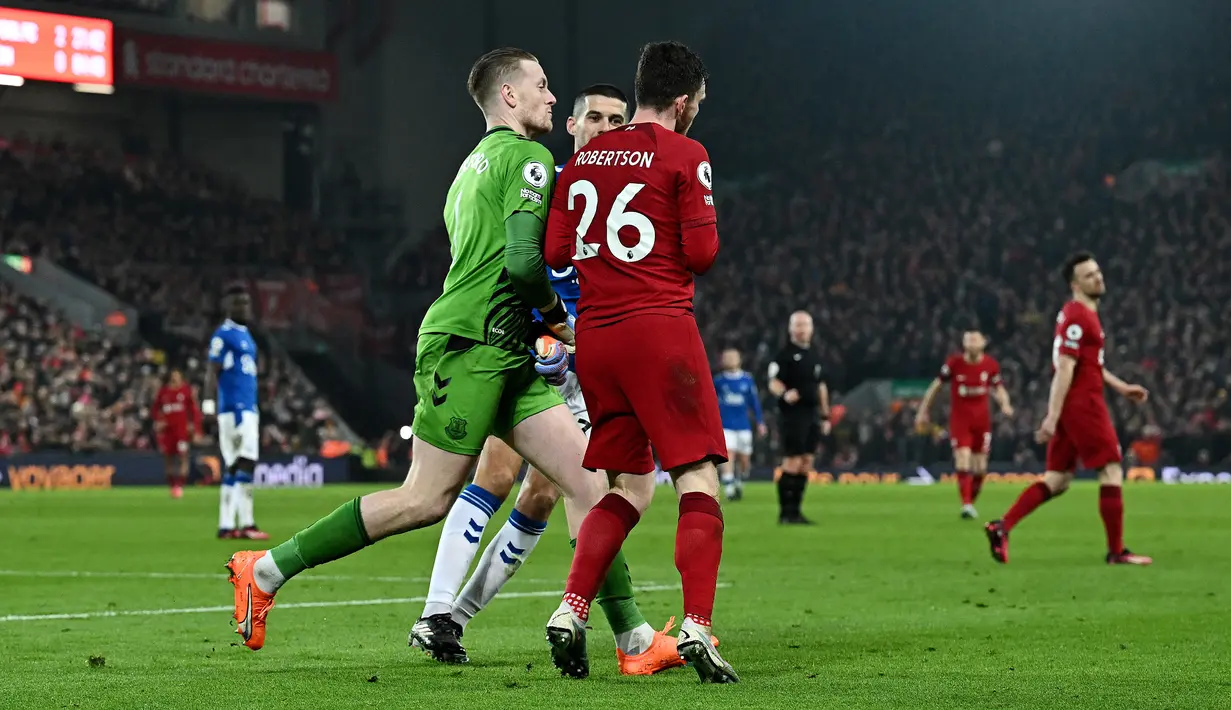 Kiper Everton, Jordan Pickford, mendorong pemain Liverpool, Andrew Robertson, pada laga Liga Inggris di Stadion Anfield, Selasa (14/2/2023). Pickford yang kesal lalu menabrakkan tubuhnya ke Robertson yang tertawa. (AFP/Paul Ellis)