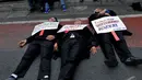 Tiga orang pengacara tidur telentang di jalan raya sebagai bentuk protes mereka kepada rencana pengesahan RUU Advokat oleh DPR, Jakarta, Kamis (11/9/2014) (Liputan6.com/Johan Tallo)