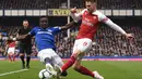 Idrisa Gueye mencoba menghentikan umpan Aaron Ramsey pada laga lanjutan Premier League yang berlangsung di Stadion Goodison Park, Liverpool, Minggu (7/4). Arsenal kalah 0-1 kontra Everton. (AFP/Oli Scarff)