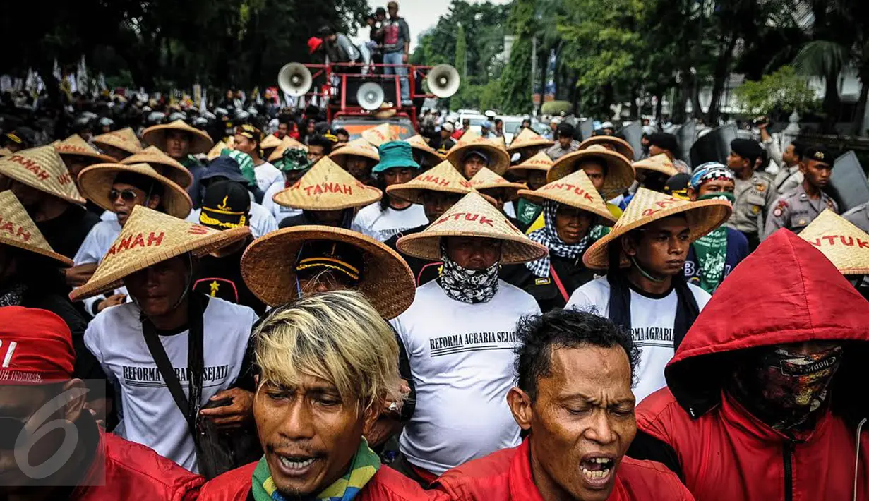 Massa yang mengatasnamakan petani dari berbagai provinsi mengenakan topi caping saat menggelar demonstrasi di kawasan Medan Merdeka, Jakarta, Selasa (27/9). Aksi tersebut digelar dalam rangka memperingati Hari Tani Nasional. (Liputan6.com/Faizal Fanani)