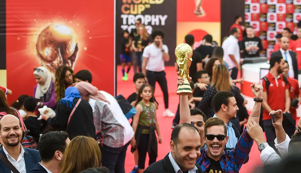 Sejumlah warga saat acara tur dunia trofi Piala Dunia FIFA  2018 di Ibu Kota Kairo, Mesir (15/3). Trofi ini terbuat dari emas murni 18 karat dengan dasar perunggu, setinggi 36,8 sentimeter dan berat 6,1 kilogram. (AFP Photo/Khaled Desouki)