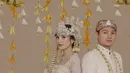 Ini adalah momen pre-wedding di mana Beby Tsabina dan Rizki Natakusumah tampil memesona dalam balutan baju pengantin adat Sunda berwarna putih. Mereka memadukannya dengan kain batik yang serasi sebagai bawahan. [Foto: Instagram/bebytsabina]