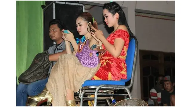 Sebelum sukses menjadi penyanyi dangdut, Nella duduk bersama dengan biduan lain di samping panggung sembari menunggu gilirannya tampil.