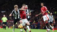 Pemain depan Manchester United asal Denmark Rasmus Hojlund (tengah) ditahan oleh gelandang Newcastle United asal Inggris Lewis Hall (kiri) selama pertandingan sepak bola Liga Primer Inggris antara Manchester United dan Newcastle United di Old Trafford di Manchester, Inggris barat laut, pada tanggal 30 Desember 2024.Darren Staples / AFP