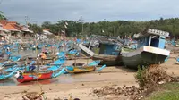 Nelayan memarkirkan perahu saat musim badai Cempaka di selatan Jawa (Liputan6.com / Jayadi Supriadin)