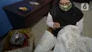 Ibu rumah tangga menyelesaikan pembuatan batik kembang mayang di Kampung Batik, Kelurahan Larangan Selatan, Kota Tangerang, Banten, Rabu (26/8/2020). Di tempat yang menjadi destinasi wisata tersebut kita bisa melihat langsung pembuatan dan mengikuti pelatihan membatik. (merdeka.com/Dwi Narwoko)