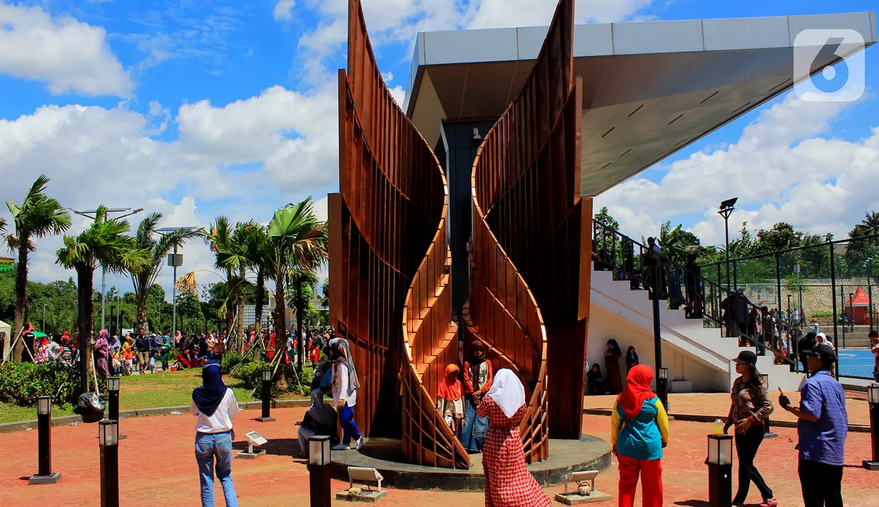 Warga berfoto dengan instalasi seni yang menghiasi Alun-Alun Kota Depok, Minggu (12/1/2020). Alun-alun seluas 3,9 hektare ini dilengkapi berbagai fasilitas, mulai dari padepokan, wall climbing, skate park, working space, hingga gerai UMKM. (Merdeka.com/Muhammad Fayyadh/Magang)
