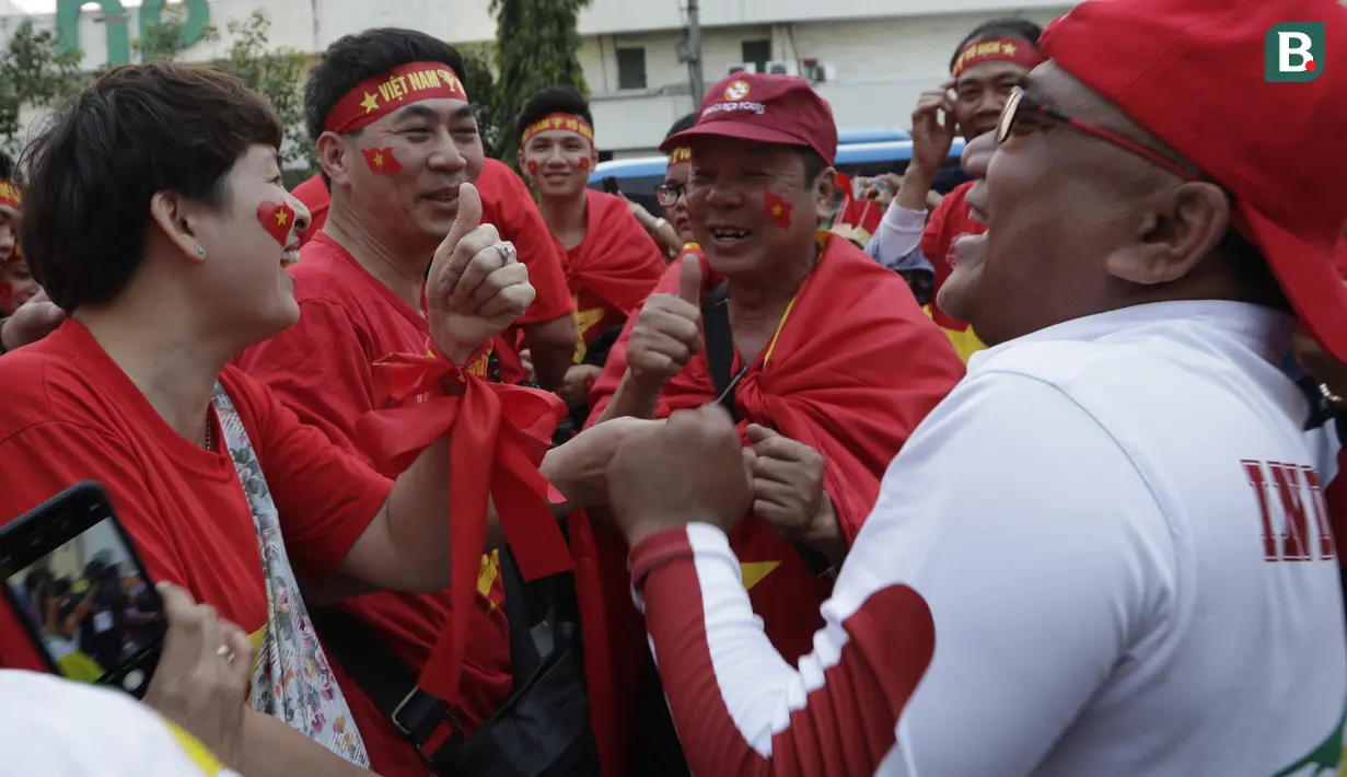 Suporter Timnas Indonesia U-22 dan Vietnam U-22 bernyanyi bersama jelang laga final SEA Games 2019 di Stadion Rizal Memorial, Manila, Selasa (10/12). Meski bersaing para suporter tetap akrab. (Bola.com/M Iqbal Ichsan)
