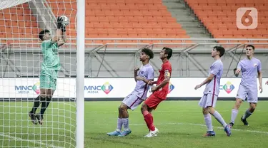 Kiper Indonesia All Star U-20 Ahludz Dzikri Fikri (kiri) menangkap bola saat bermain melawan FC Barcelona U-18 pada pertandingan International Youth Championship 2021 di Jakarta International Stadium, Jakarta, Rabu (13/4/2022). Pertandingan berakhir imbang 0-0. (Liputan6.com/Faizal Fanani)