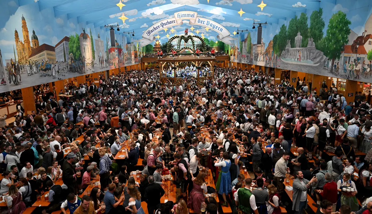 Para pengunjung festival berkumpul dan bersorak di tenda bir selama festival bir Oktoberfest di pasar malam Theresienwiese di Munich, Jerman selatan (20/9/2022). Festival Bir yang terkenal di dunia ini akan berlangsung hingga 3 Oktober 2022 tanpa batasan akses, setelah dua hari terakhir edisi tahun telah dibatalkan karena pandemi coronavirus. (AFP/Christof Stache)