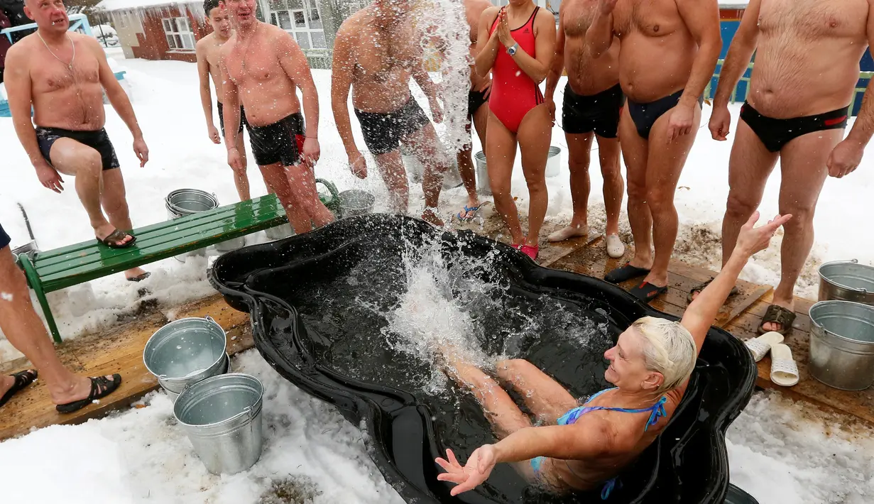 Seorang wanita mengenakan pakaian renang berendam di kolam kecil saat perayaan hari Polar Bear di kebun binatang Royev Ruchey, Krasnoyarsk, Rusia (27/11). (Reuters/Ilya Naymushin)