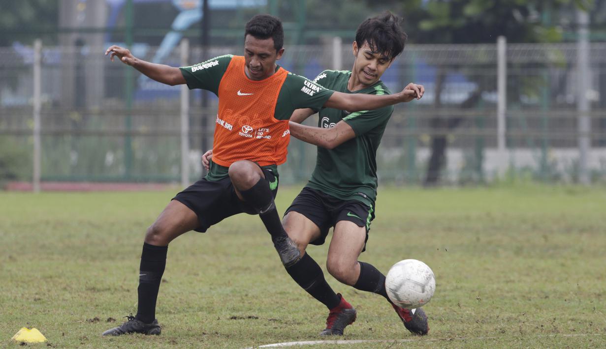 Pemain Timnas Indonesia U-22, Syafril Lestaluhu, berebut bola dengan Lutfhi Kamal saat latihan di Lapangan ABC, Jakarta, Senin (14/1). Latihan ini merupakan persiapan jelang Piala AFF U-22. (Bola.com/Vitalis Yogi Trisna)