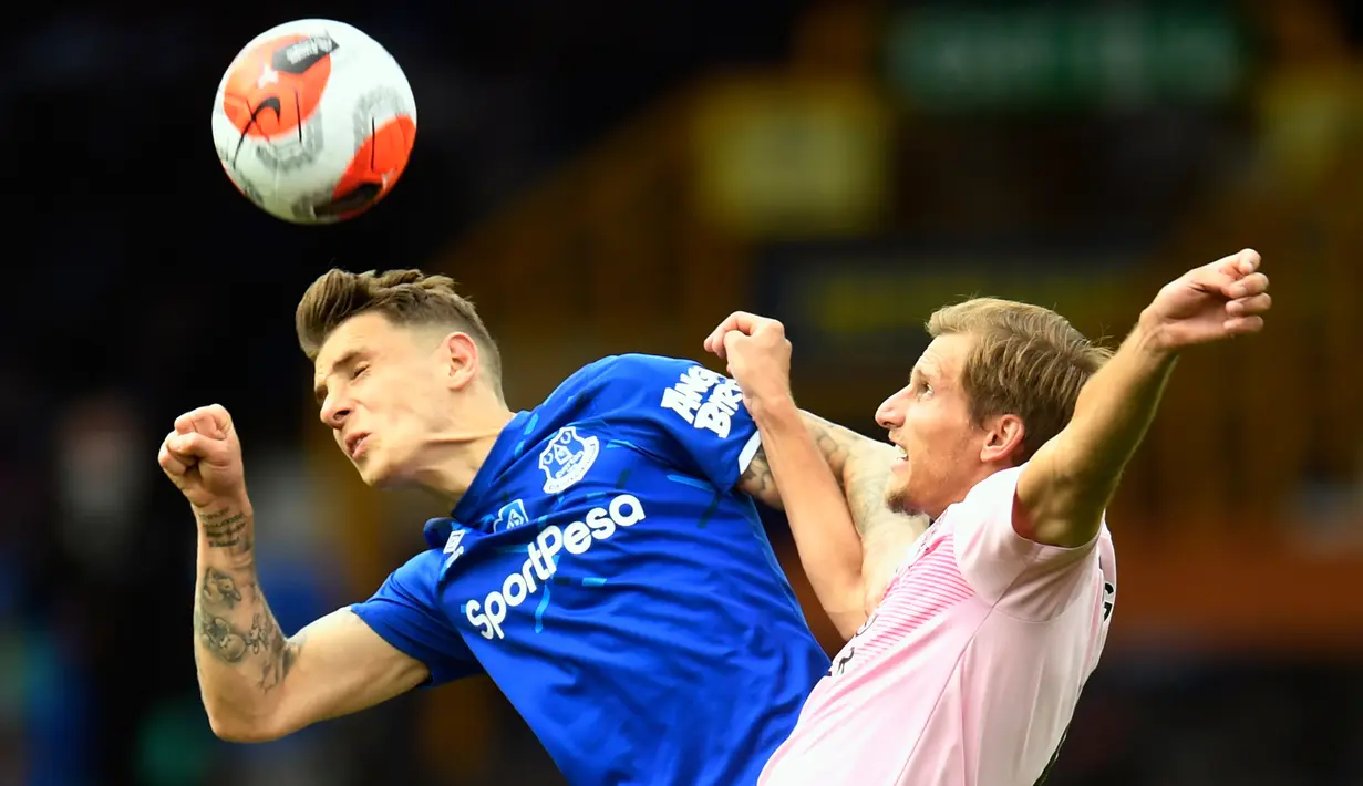 Pemain Everton, Lucas Digne (kiri) berebut bola udara dengan pemain Leicester City, Marc Albrighton pada pertandingan lanjutan Liga Inggris di di Goodison Park di Liverpool, Inggris, Rabu (1/7/2020). Everton menang tipis atas Leicester City 2-1. (Peter Powell / Pool via AP)