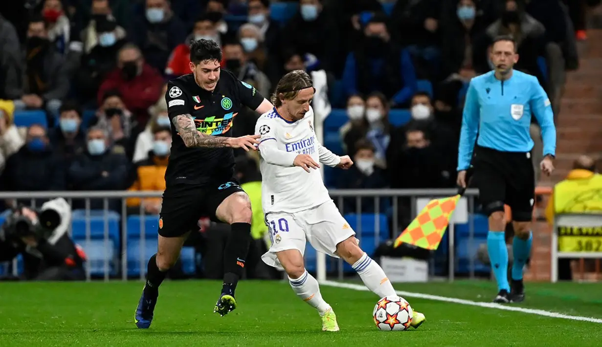 Pemain Inter Milan Alessandro Bastoni (kiri) berebut bola dengan pemain Real Madrid Luka Modric pada pertandingan sepak bola Grup D Liga Champions di Stadion Santiago Bernabeu, Madrid, Spanyol, 7 Desember 2021. Real Madrid menang 2-0. (PIERRE-PHILIPPE MARCOU/AFP)