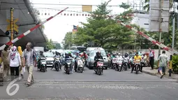 Sejumlah kendaraan menunggu kereta commuterline di perlintasan sebidang Duren Kalibata, Jakarta, (13/9). Dirjen Perkeretaapian Kemenhub usulkan Pemprov DKI Jakarta menutup 19 perlintasan sebidang di wilayah DKI Jakarta. (Liputan6.com/Yoppy Renato)