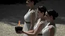 Para aktris Yunani, Katerina Lechou, membawa api olimpiade yang baru saja dinyalakan dalam suatu upacara di Candi Hera yang terletak di bekas kota tua Olympia, Yunani, Kamis (21/4/2016). (AFP/Aris Messinis)