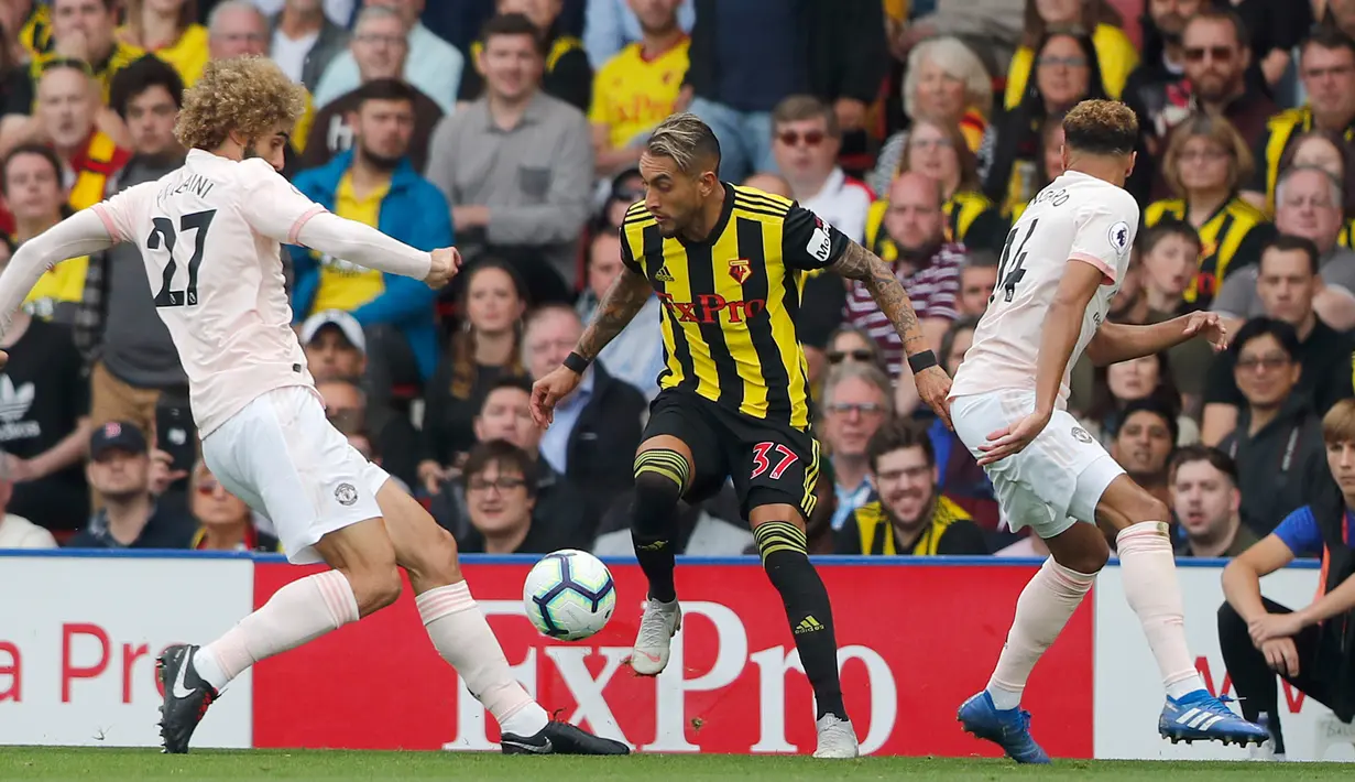 Pemain Watford, Roberto Pereyra berusaha mengontrol bola dari kawalan dua pemain Manchester United saat bertanding pada lanjutan Liga Inggris di stadion Vicarage Road, Inggris (15/9). MU menang tipis 2-1 atas Watford. (AP Photo/Frank Augstein)
