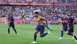 Pemain Barcelona, Ronald Araujo, melakukan selebrasi setelah mencetak gol ke gawang Girona pada laga pekan ke-9 La Liga 2025/2026 di Stadion Olimpic Lluis Companys, Sabtu (18/10) malam WIB. (AFP/Josep Lago)