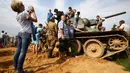 Sejumlah pengunjung berfoto diatas tank yang digunakan sebagai properti setelah pertunjukan rekonstruksi pertempuran Perang Dunia II, di Memorial "Stalin Line", dekat Desa Goroshki, Belarusia, (10/9). (Reuters/Vasily Fedosenko)