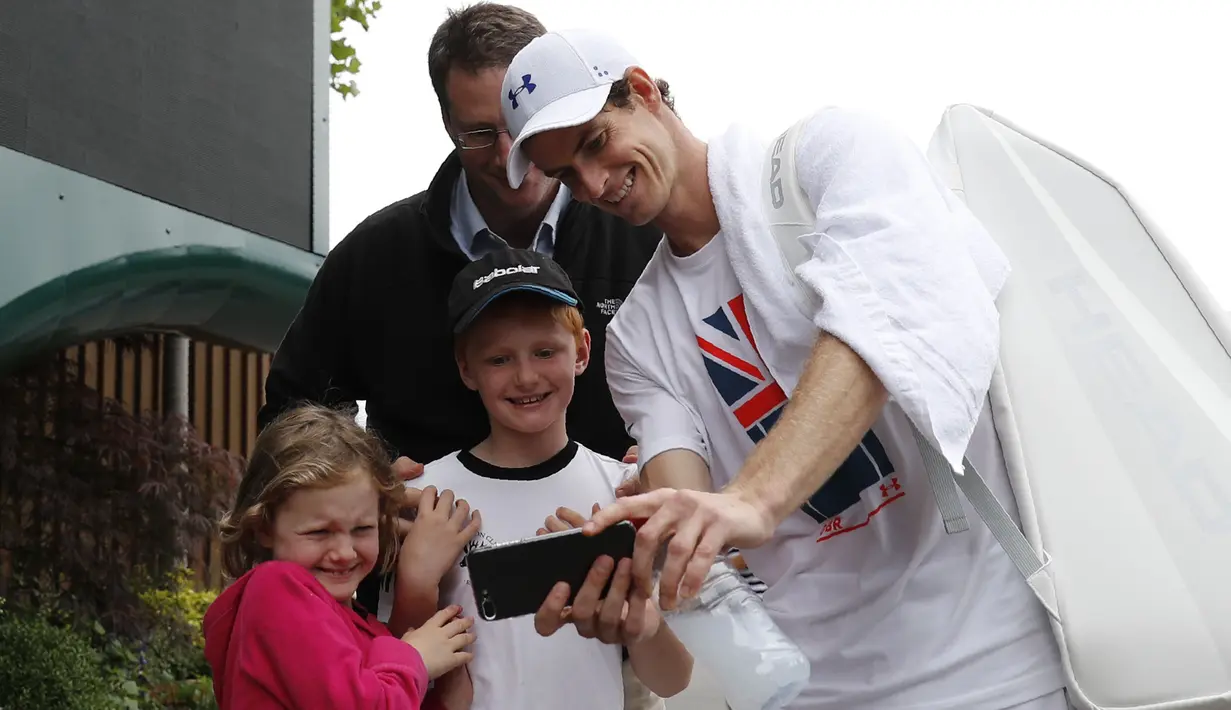 Petenis Inggris Raya, Andy Murray melakukan sesi foto selfie bersama fans usai berlatih di Wimbledon tennis club, London, (1/7/2017). Turnament Wimbledon 2017 akan berlangsung pada  3-16 Juli 2017. (AFP/Adrian Dennis)